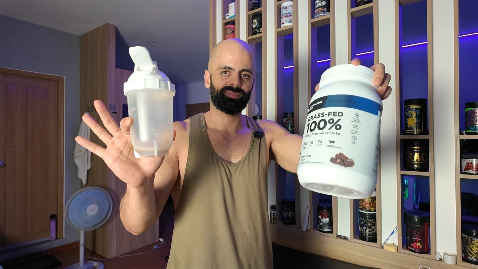 Nader holding Transparent Labs Cocoa whey protein and a mixed shaker