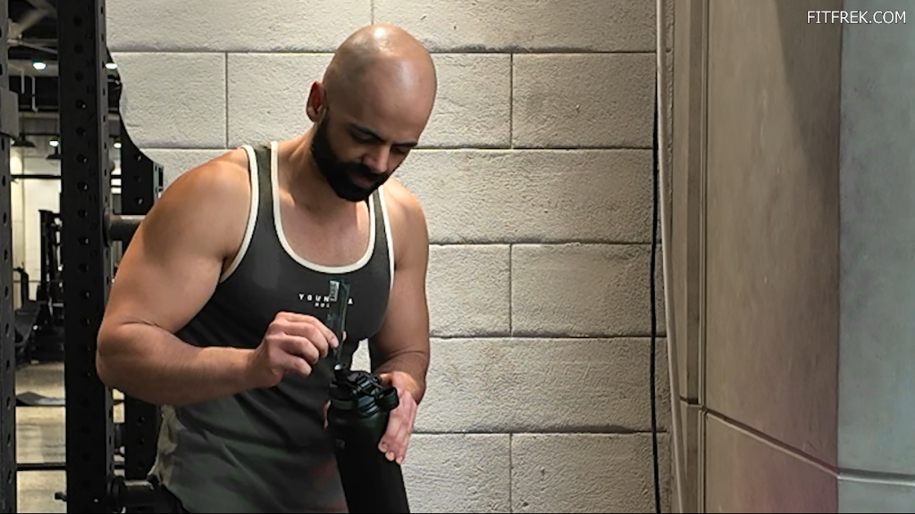FitFrek reviewer mixing Transparent Labs Hydrate Black into a workout bottle at the gym